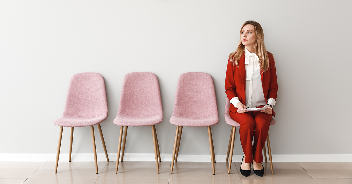 A woman sitting on a chair waiting for her interview.